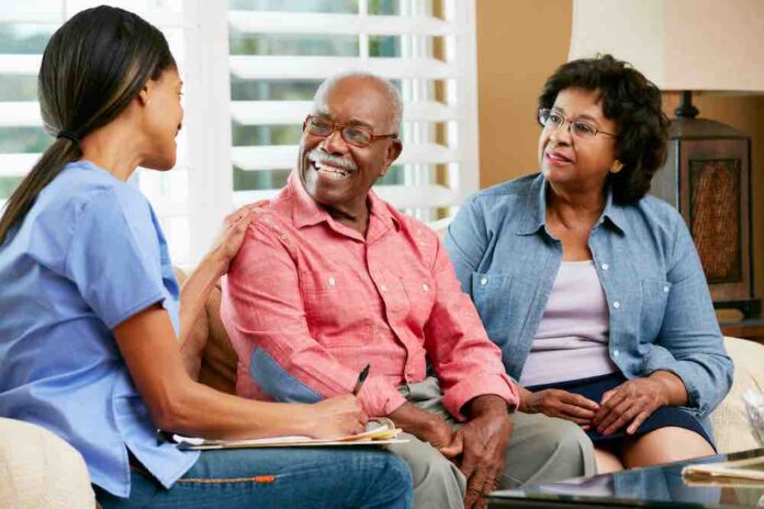 Elderly African American couple receiving medical advice from nurse