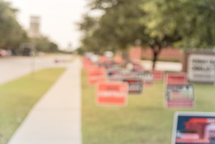 Blurred election campaign signs on front lawn