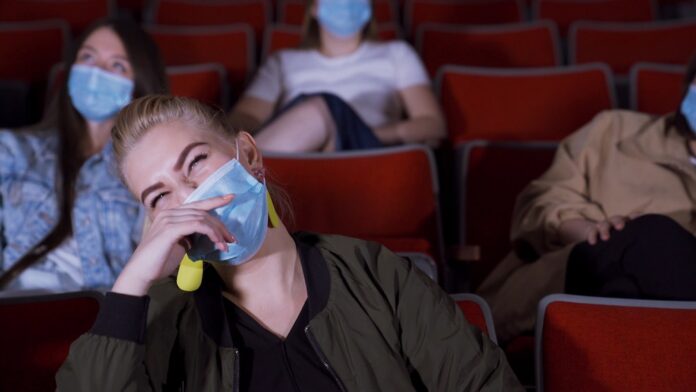 Woman in a mask watching a movie or show