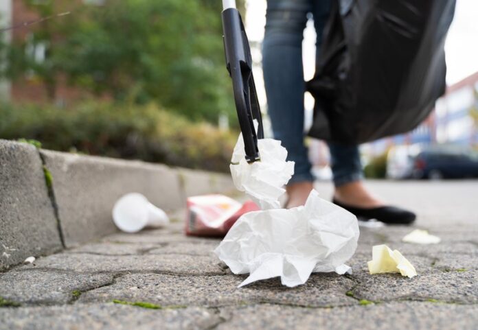 Woman picking up litter with grabber