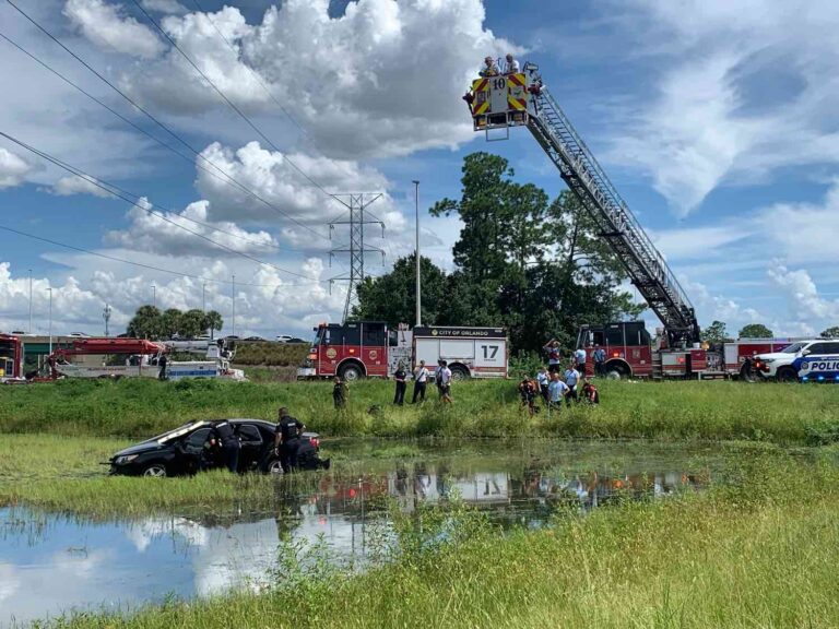 Orlando Fire crews respond to car partially submerged in pond near I-4