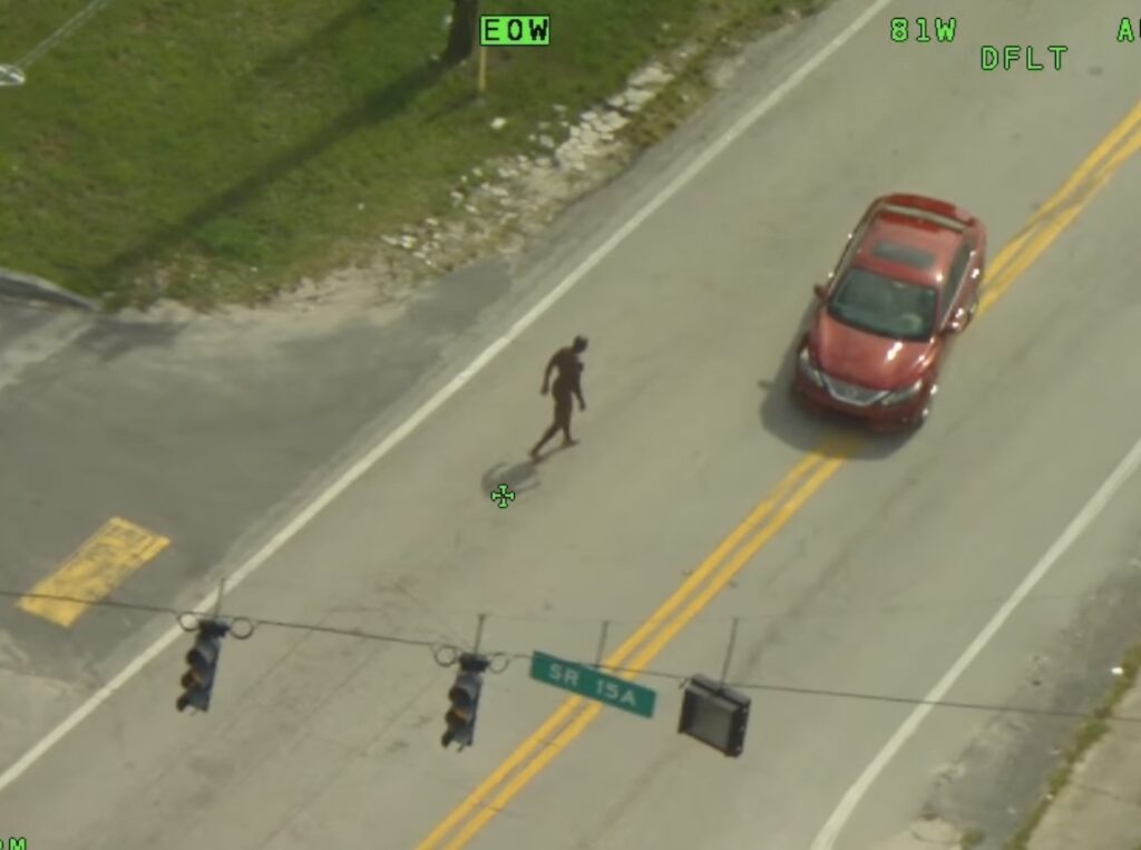 Vehicles avoid Wright as he walks towards them near a DeLand gas station on August 9