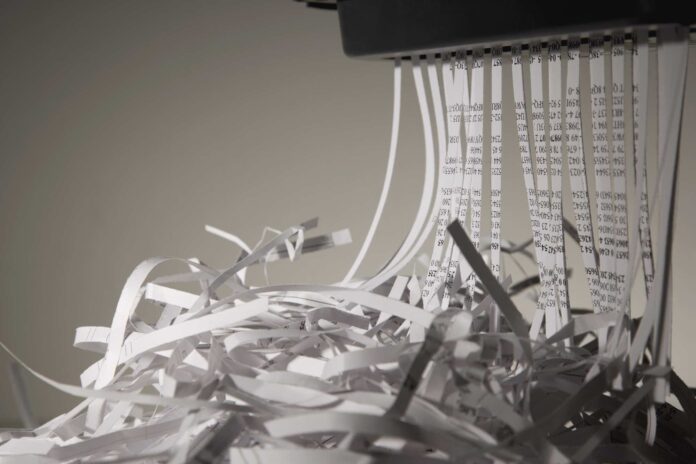 Shredded paper going into paper shredder