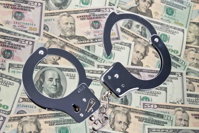 Pile of money with handcuffs to represent embezzlement