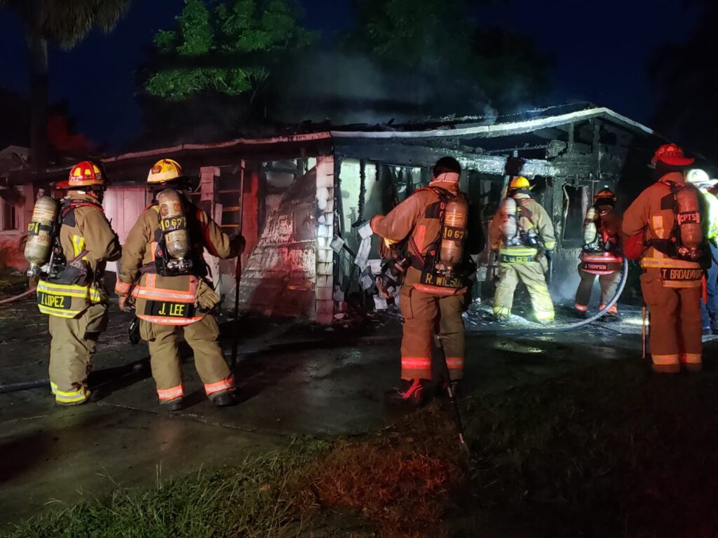 Firefighters survey a home that was destroyed by fire on August 16