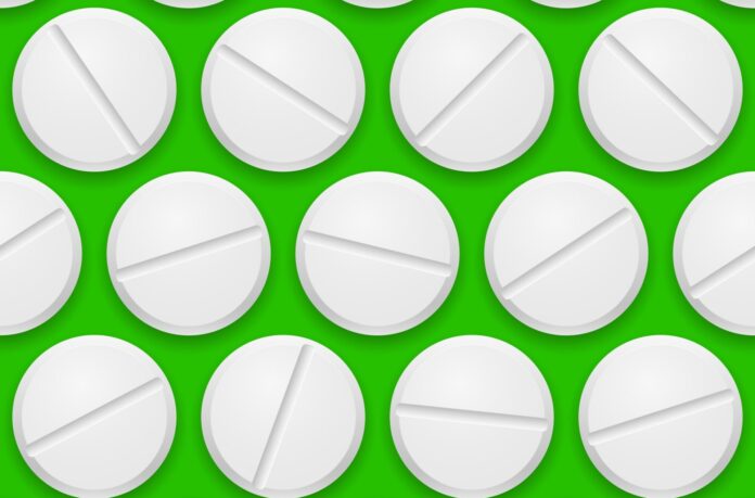 Pills in a pill press on a green background