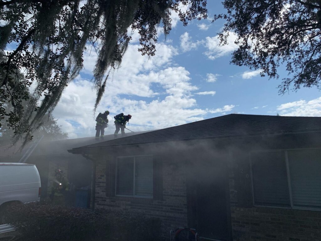 Crews work on top of a home in DeLand that is on fire December 9