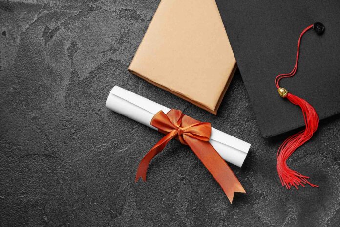 Diploma with red ribbon, graduation hat and book on black table