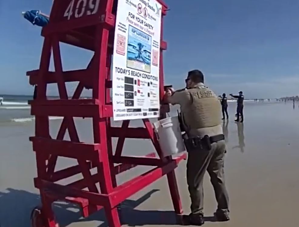 VCSO deputies at New Smyrna Beach with guns drawn as suspect stands in the water (Photo by Volusia County Sheriff's Office)