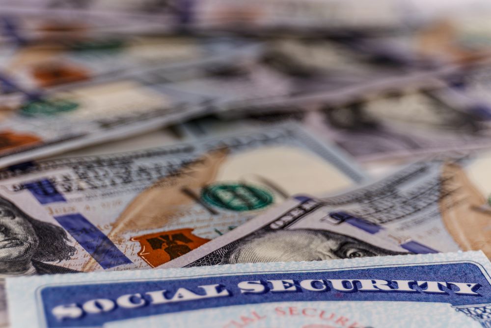 Social security card on top of large pile of bills